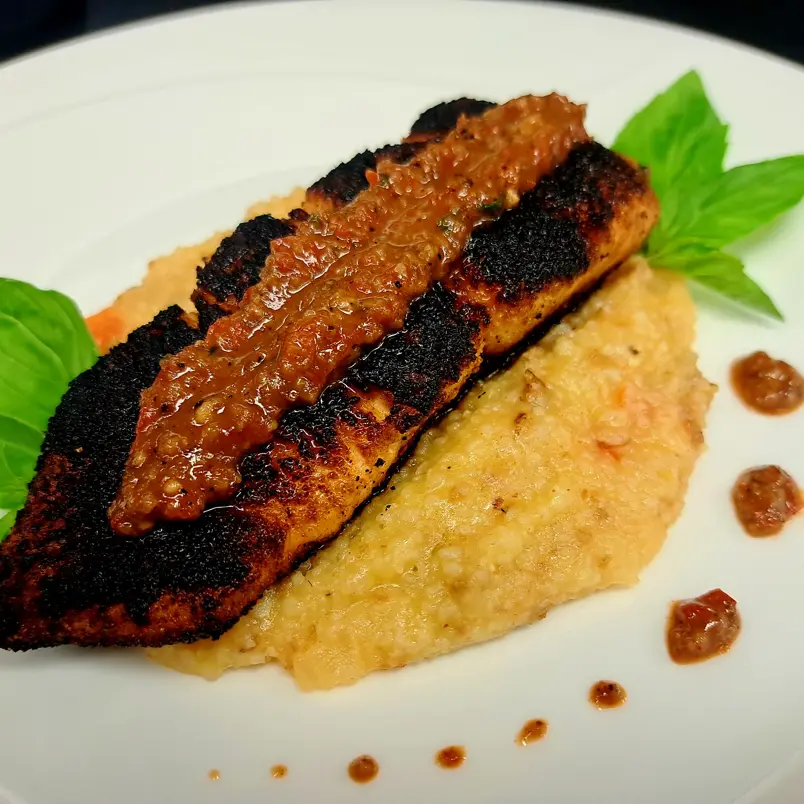 creation thumb for Blackened salmon over cheesy grits with romanesca sauce
